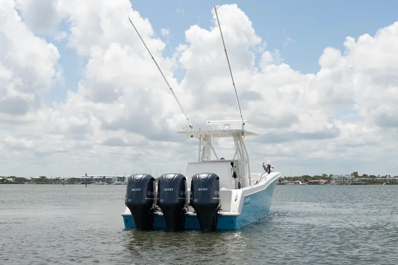  Yacht Photos Pics 2015 Invincible 36 Open Fisherman boat with triple engines on calm water.