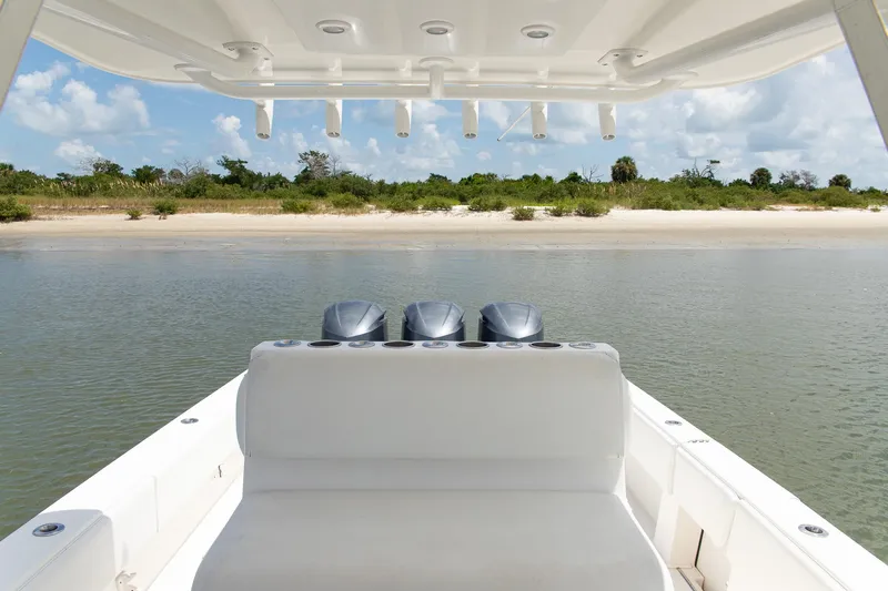  Yacht Photos Pics 2015 Invincible 36 Open Fisherman boat near sandy shore, clear sky.