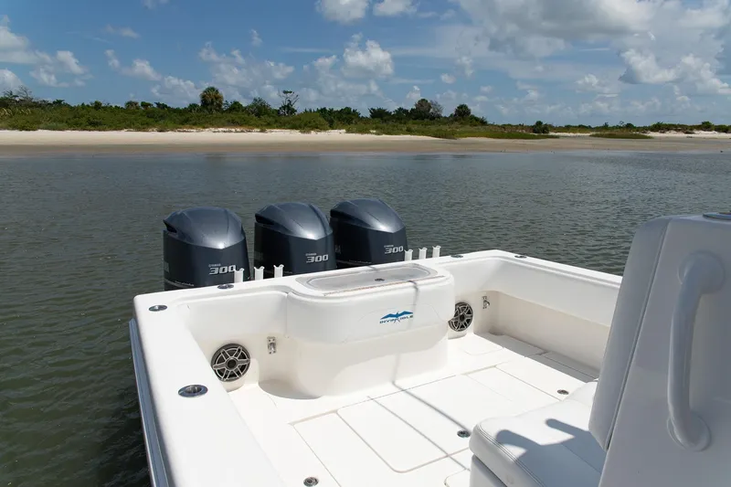  Yacht Photos Pics 2015 Invincible 36 Open Fisherman boat with triple engines, near a sandy shoreline.