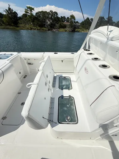  Yacht Photos Pics 2018 Sea Hunt Gamefish 30 boat with forward seating and live wells, docked by a scenic shoreline.