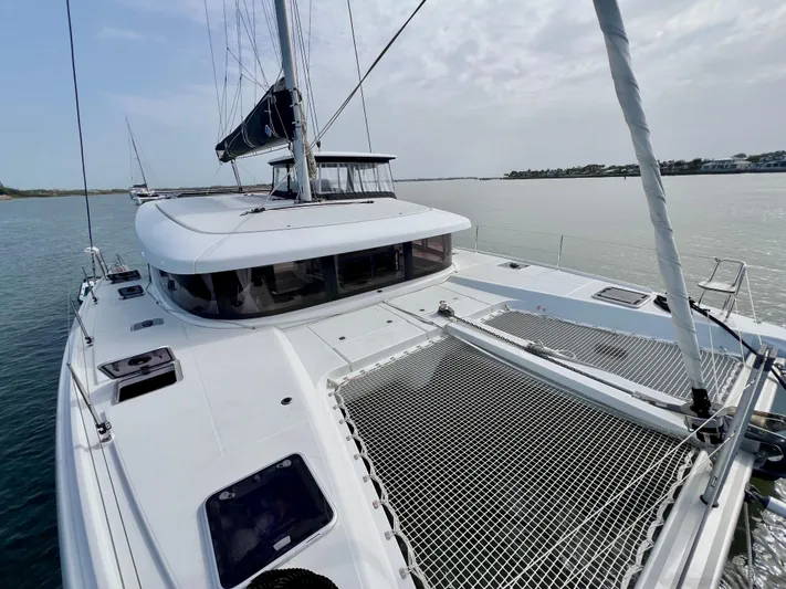 Roxie Yacht Photos Pics 2024 Lagoon 42 catamaran on calm water, featuring sleek design and spacious deck.