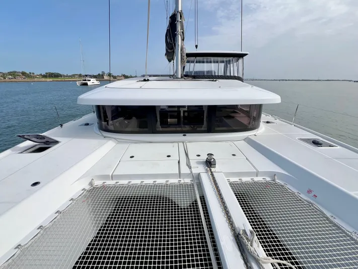 Roxie Yacht Photos Pics 2024 Lagoon 42 catamaran on calm water, showcasing sleek design and spacious deck.