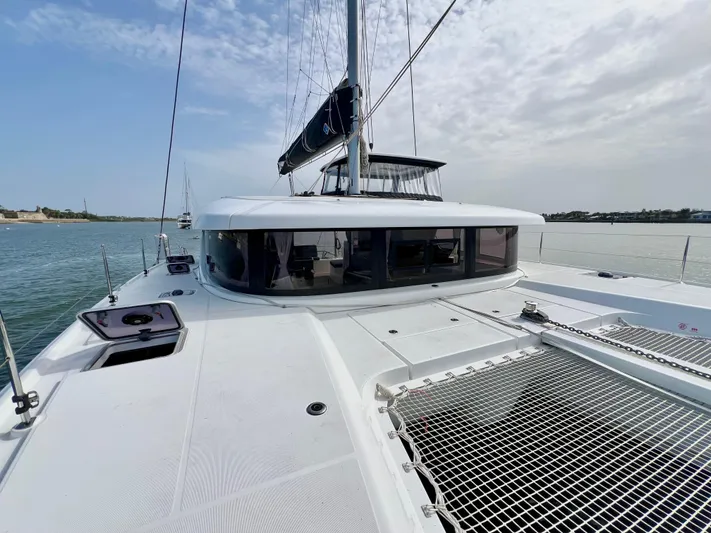 Roxie Yacht Photos Pics 2024 Lagoon 42 catamaran on calm water, showcasing sleek deck and modern design.