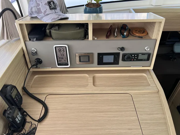 Roxie Yacht Photos Pics Control panel of a 2024 Lagoon 42 yacht with navigation instruments and storage compartments.