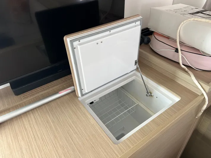 Roxie Yacht Photos Pics Open storage compartment on a 2024 Lagoon 42 yacht, featuring a wooden countertop.