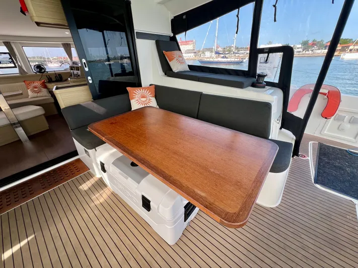 Roxie Yacht Photos Pics 2024 Lagoon 42 yacht interior with wooden table, cushioned seating, and marina view.