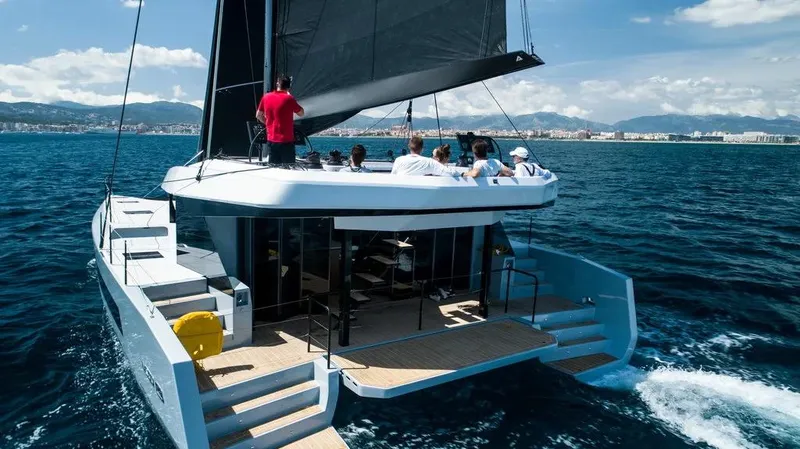  Yacht Photos Pics 2026 McConaghy MC55 catamaran sailing with passengers on a sunny day.