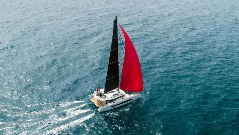  Yacht Photos Pics Sailing yacht McConaghy MC55 2026 with black and red sails on open sea.