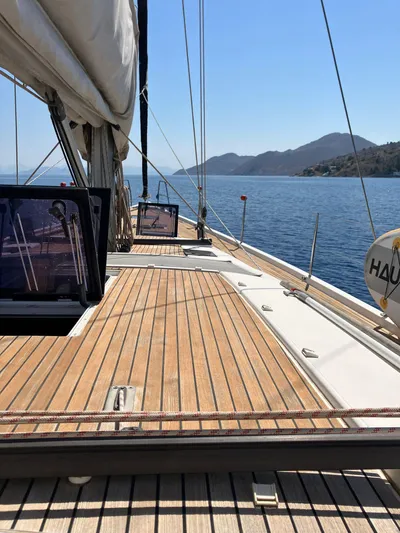 Southern Cross Yacht Photos Pics Sailing yacht Dufour 560 Grand Large 2015 on calm sea with scenic mountain backdrop.