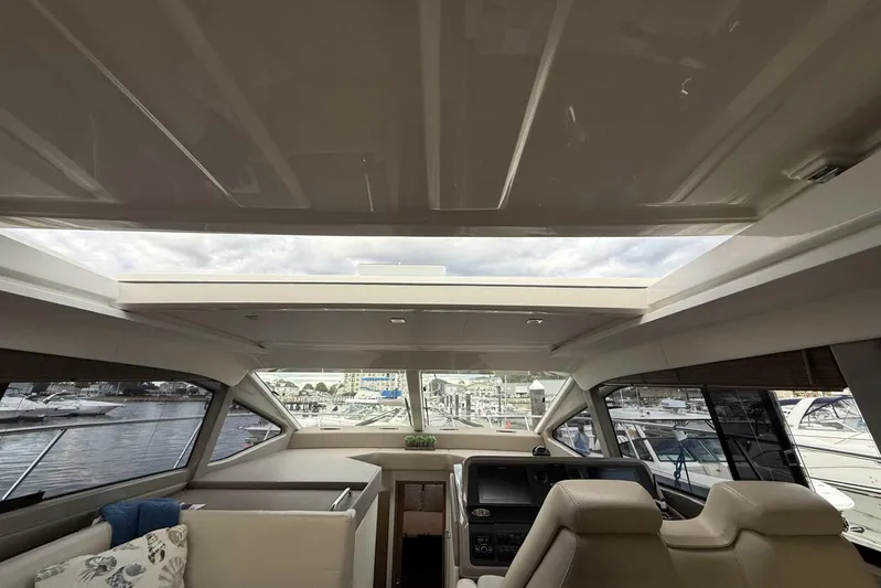  Yacht Photos Pics Interior view of 2018 Sea Ray Sundancer 460 yacht with open sunroof and marina backdrop.