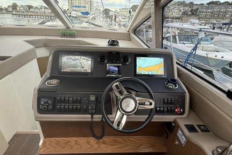  Yacht Photos Pics 2018 Sea Ray Sundancer 460 helm with navigation screens and steering wheel, docked at marina.