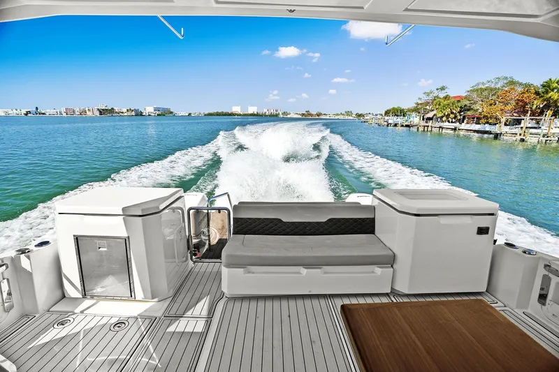  Yacht Photos Pics Aquila 36 boat cruising on clear blue water, leaving a wake behind.