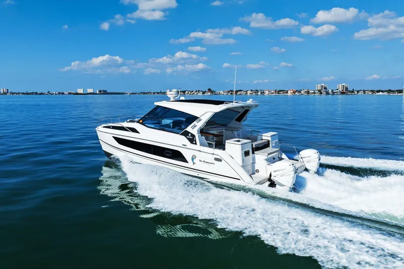  Yacht Photos Pics Aquila 36 boat cruising on a sunny day, 2020 model, with city skyline in background.