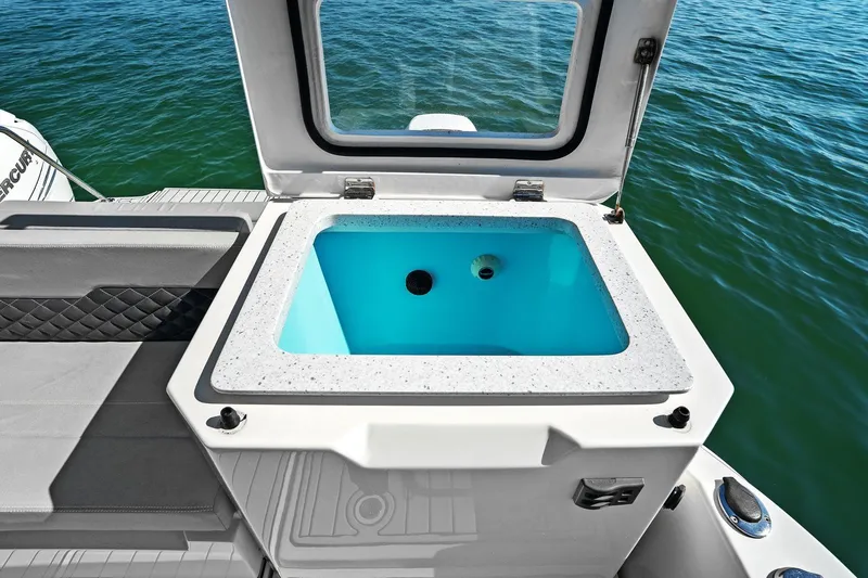  Yacht Photos Pics Aquila 36 boat livewell with open lid, showcasing blue interior against ocean backdrop.
