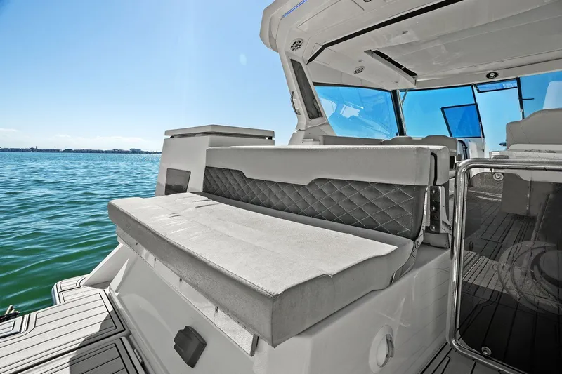  Yacht Photos Pics Aquila 36 boat interior with cushioned seating, overlooking calm blue waters.