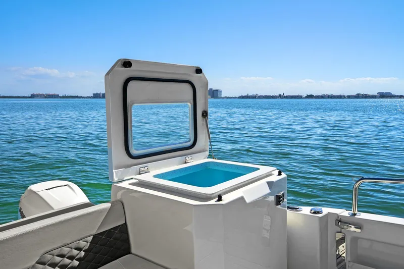  Yacht Photos Pics Aquila 36 boat with open storage compartment, overlooking serene blue waters.