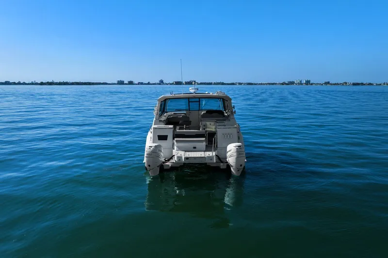  Yacht Photos Pics Aquila 36 boat from 2020 on calm blue water, distant shoreline visible.