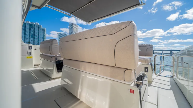  Yacht Photos Pics Luxurious YOT 36 yacht deck with modern seating, city skyline, and blue sky, 2025 model.