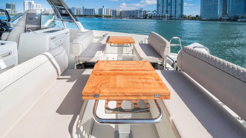  Yacht Photos Pics Luxurious 2025 YOT 36 yacht with elegant seating and wooden tables, overlooking a scenic waterfront.