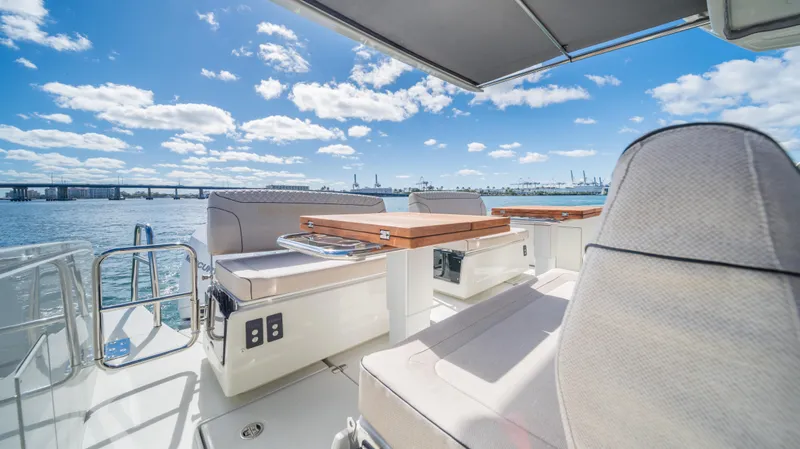  Yacht Photos Pics Luxurious 2025 YOT 36 yacht deck with seating, overlooking a scenic waterfront view.