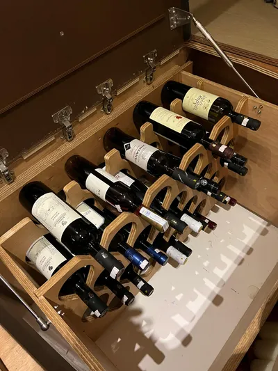 Southern Cross Yacht Photos Pics Wine rack on 2015 Dufour 560 Grand Large yacht, holding assorted wine bottles.