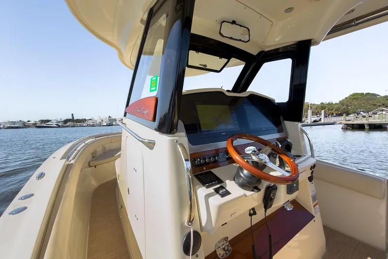 Our Trade Yacht Photos Pics 2019 Chris-Craft Catalina 30 helm with wooden steering wheel, docked by the water.