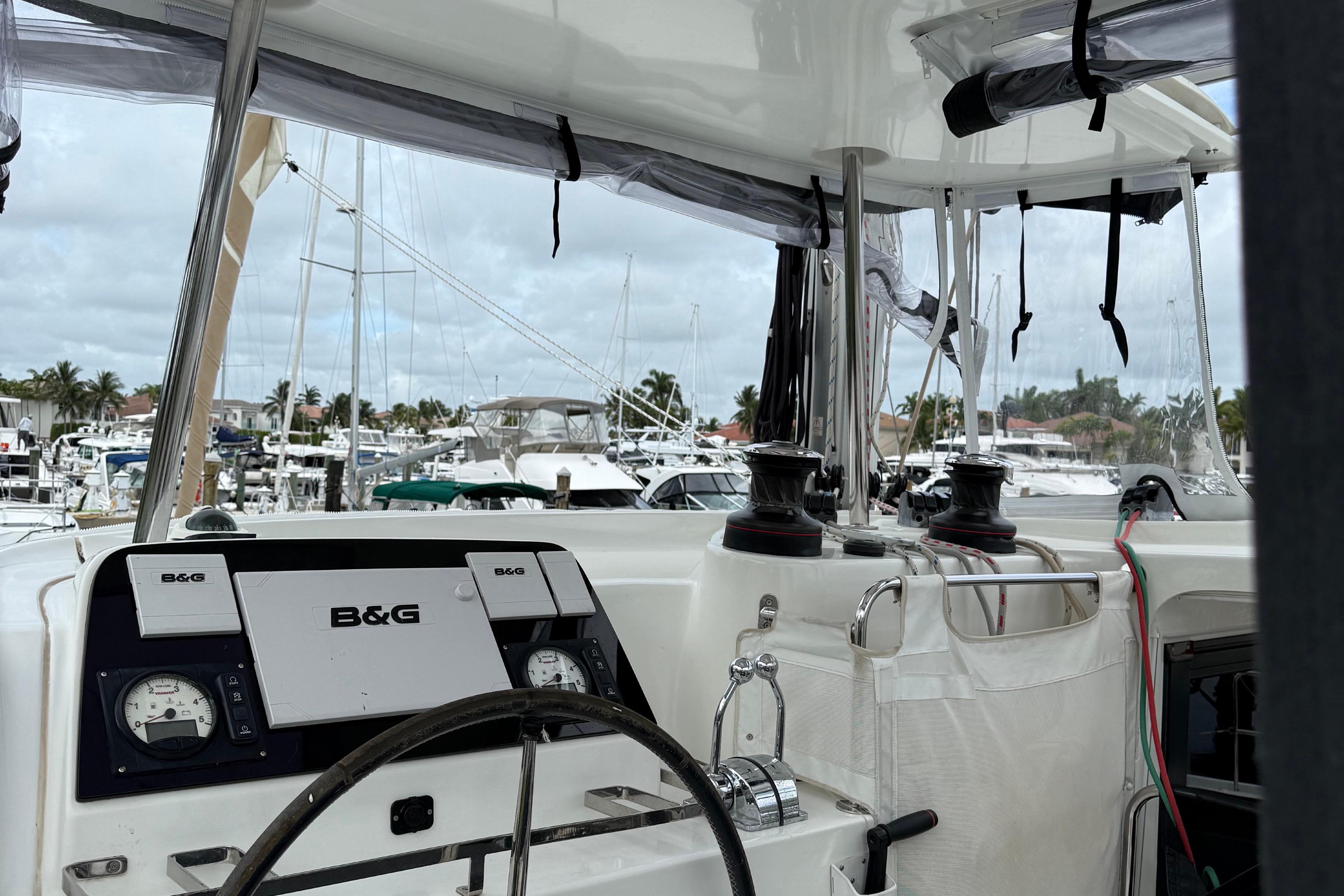 Cockpit view of 2019 Lagoon 42 catamaran with B&G navigation system in a marina.