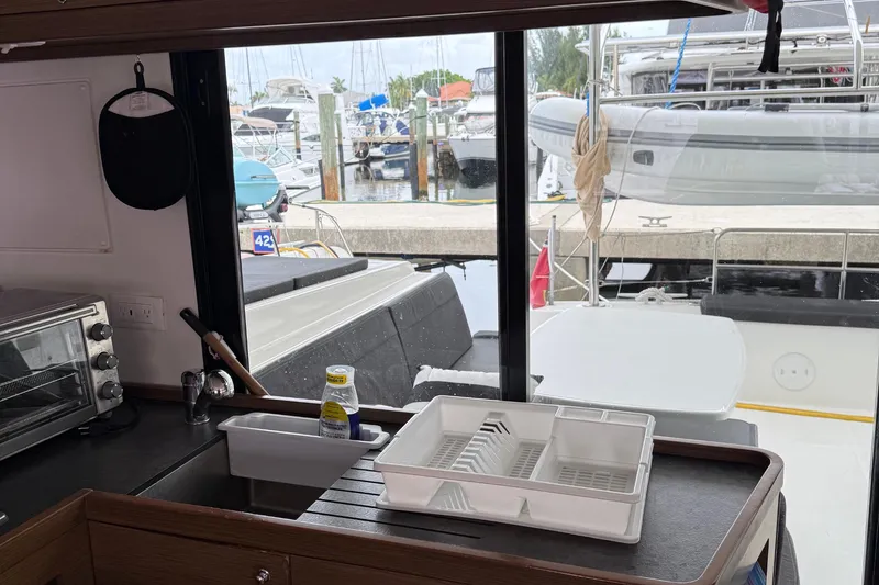 Jelliblu Yacht Photos Pics Interior view of 2019 Lagoon 42 yacht kitchen with marina backdrop.