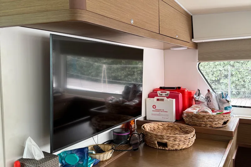Jelliblu Yacht Photos Pics Interior of 2019 Lagoon 42 yacht with TV, storage baskets, and first aid kit.