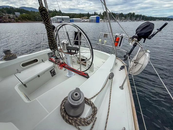 Ulrica Yacht Photos Pics 1997 Sabre 402 sailboat cockpit with steering wheel, ropes, and scenic waterfront view.