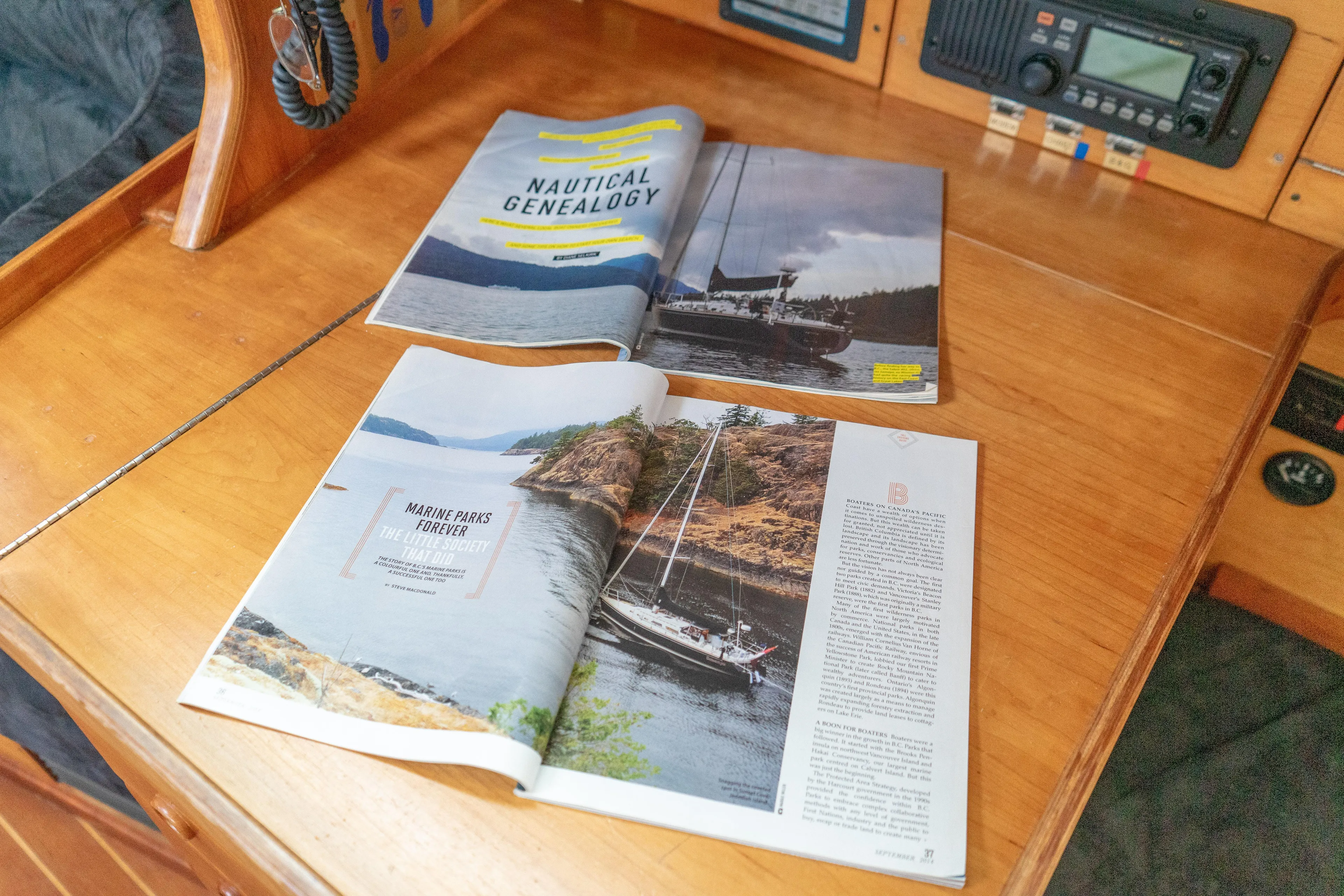 Ulrica Yacht Photos Pics Open magazines on a wooden table inside a 1997 Sabre 402 sailboat cabin.