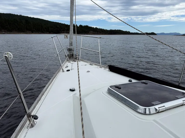 Ulrica Yacht Photos Pics Sailing on a 1997 Sabre 402 yacht, calm waters, forested shoreline, cloudy sky.