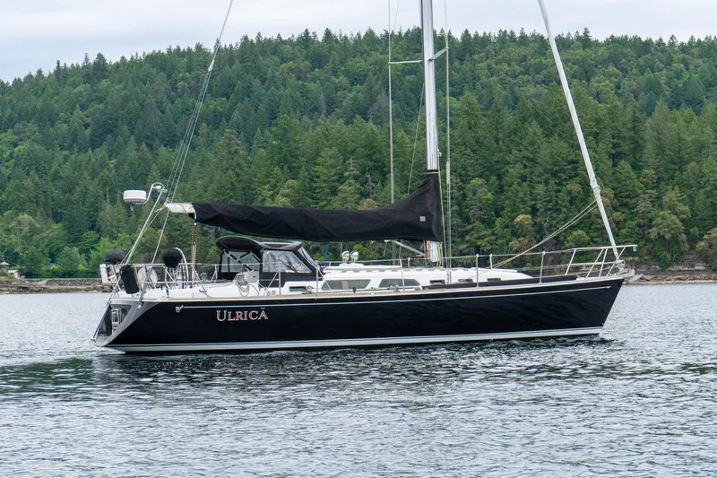 Ulrica Yacht Photos Pics Sailing yacht Sabre 402, 1997 model, cruising on a serene lake with forested backdrop.