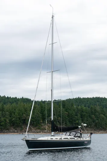 Ulrica Yacht Photos Pics Sailboat on calm water, 1997 Sabre 402, with forested shoreline in background.