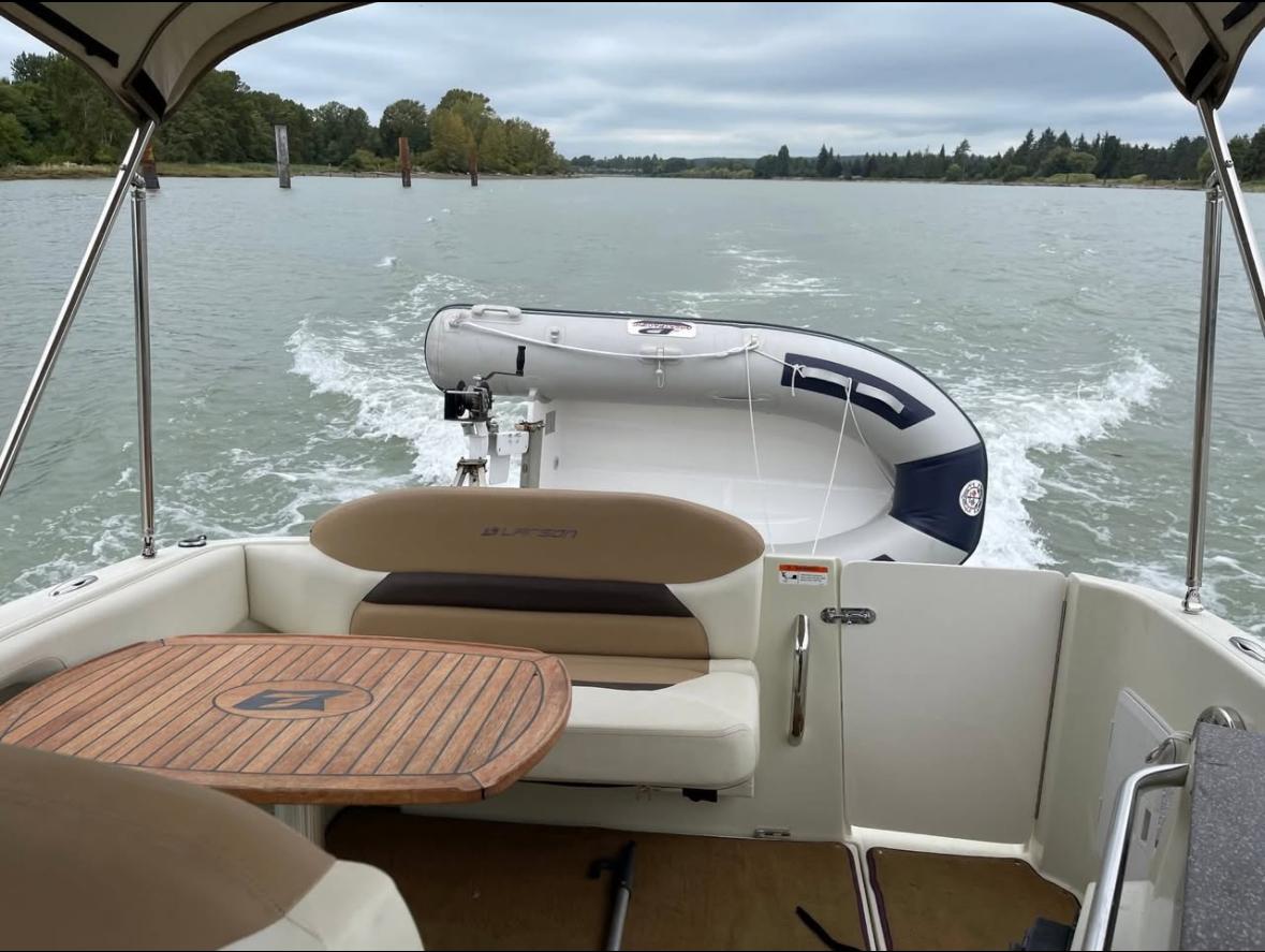 2014 Larson Cabrio 285 boat interior with table, seating, and view of water.