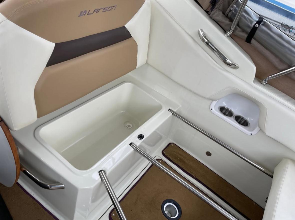 2014 Larson Cabrio 285 boat interior with seating and storage compartment.