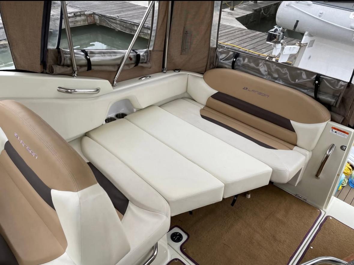 2014 Larson Cabrio 285 boat interior with beige and brown seating, docked at marina.