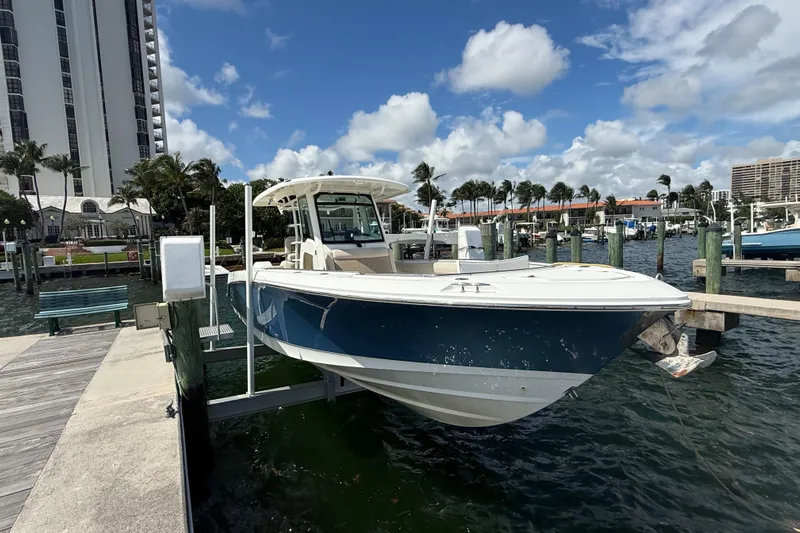 Dulce Vita Yacht Photos Pics 2016 Boston Whaler 330 Outrage docked at marina, blue sky, palm trees in background.