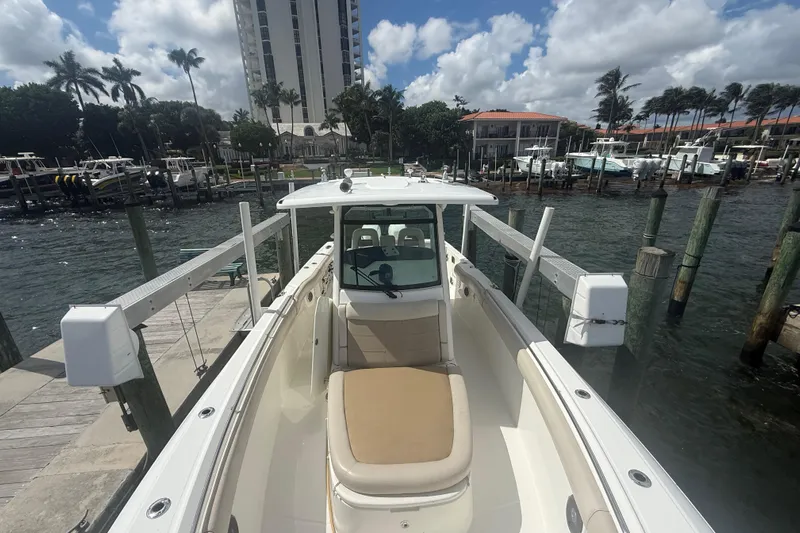 Dulce Vita Yacht Photos Pics 2016 Boston Whaler 330 Outrage docked at marina, surrounded by palm trees and buildings.