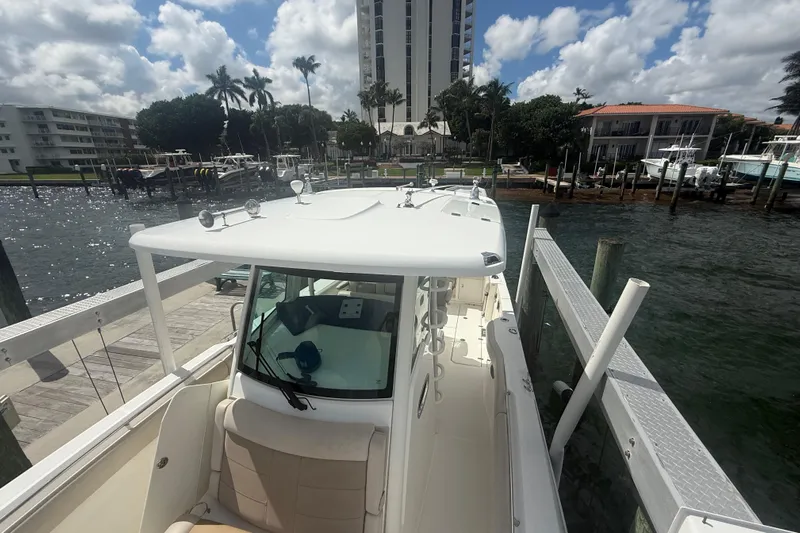 Dulce Vita Yacht Photos Pics 2016 Boston Whaler 330 Outrage docked at marina, surrounded by waterfront buildings.