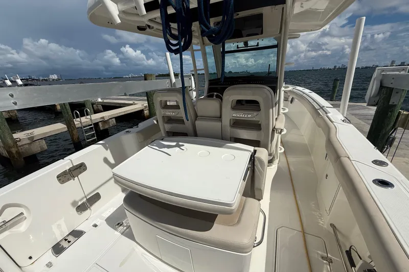 Dulce Vita Yacht Photos Pics 2016 Boston Whaler 330 Outrage boat interior at dock, featuring seating and table.