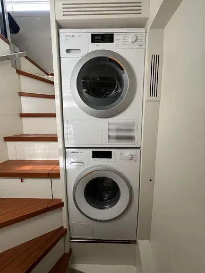 Armaar Yacht Photos Pics Stacked washer and dryer in Astondoa AS100 Century yacht, 2017 model, near wooden staircase.