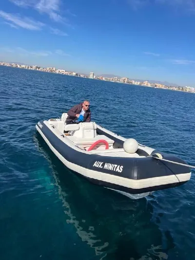 Armaar Yacht Photos Pics Man on small boat in open water, clear sky, distant cityscape.