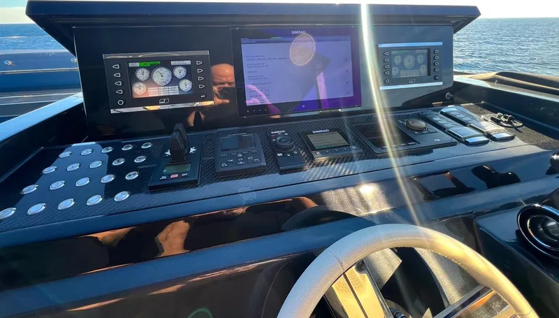 Armaar Yacht Photos Pics Control panel of 2017 Astondoa AS100 Century yacht with navigation screens and steering wheel.