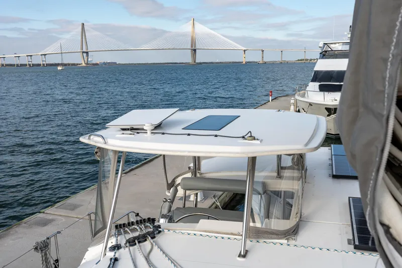 Everything Zen Yacht Photos Pics 2017 Leopard 40 catamaran docked near a bridge, with clear blue water and sky.