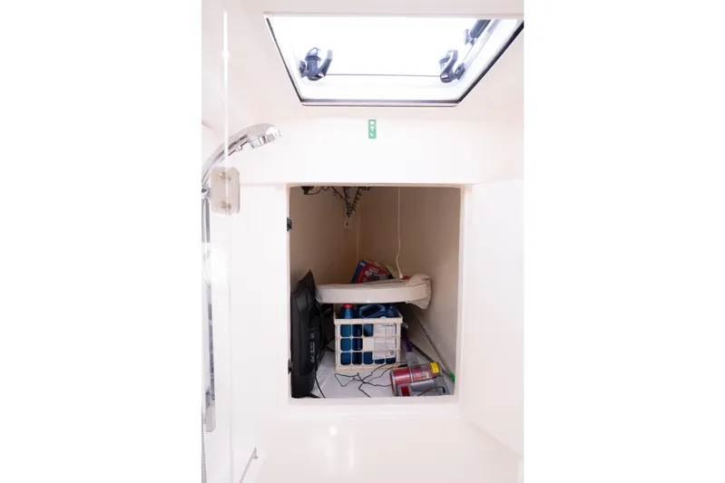 Everything Zen Yacht Photos Pics Storage compartment inside a 2017 Leopard 40 catamaran, featuring various items and a skylight.