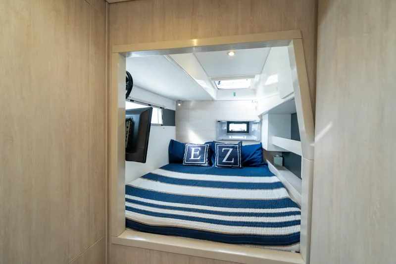 Everything Zen Yacht Photos Pics Cozy cabin interior of 2017 Leopard 40 catamaran with striped bedding and nautical decor.