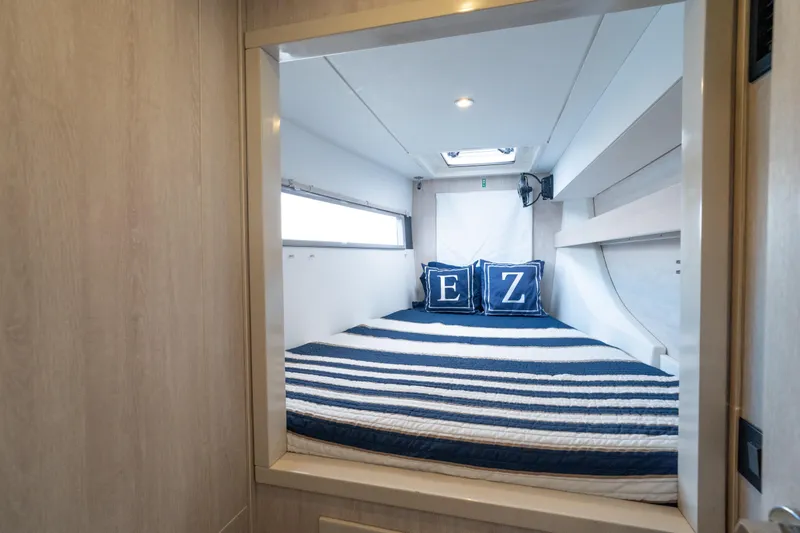 Everything Zen Yacht Photos Pics Cozy cabin interior of 2017 Leopard 40 catamaran with striped bedding and decorative pillows.