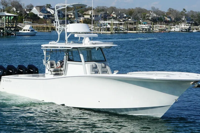  Yacht Photos Pics 2025 Onslow Bay 41 Tournament boat cruising in a marina with waterfront homes.