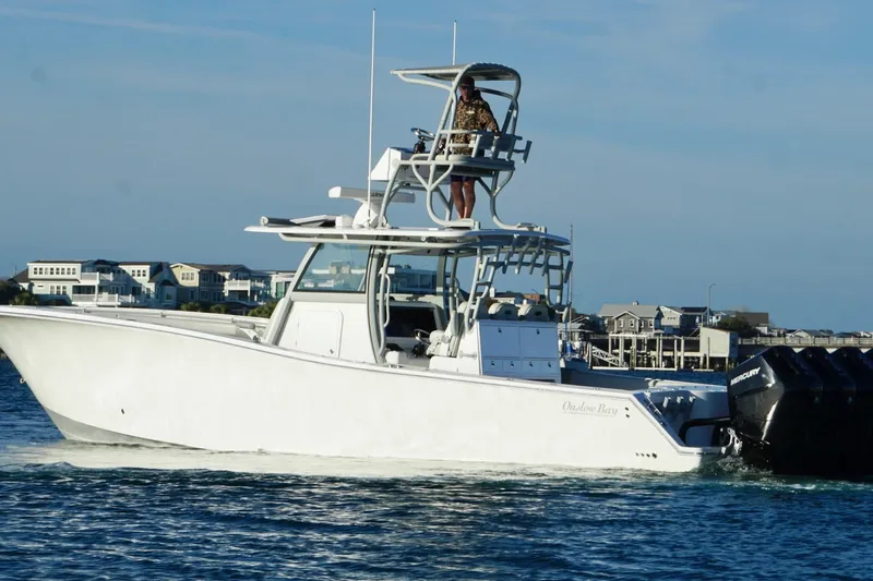  Yacht Photos Pics 2025 Onslow Bay 41 Tournament boat cruising on water near coastal homes.